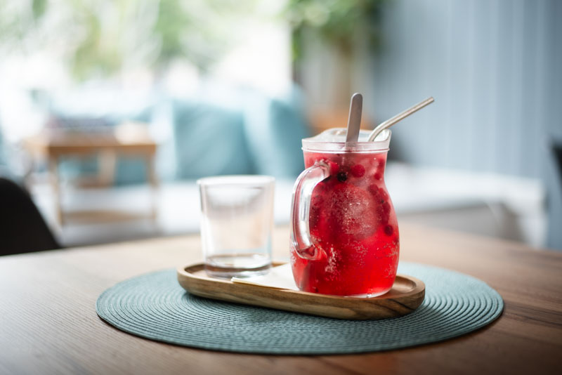 Muž v kabátu a čepici stojí před industriální budovou