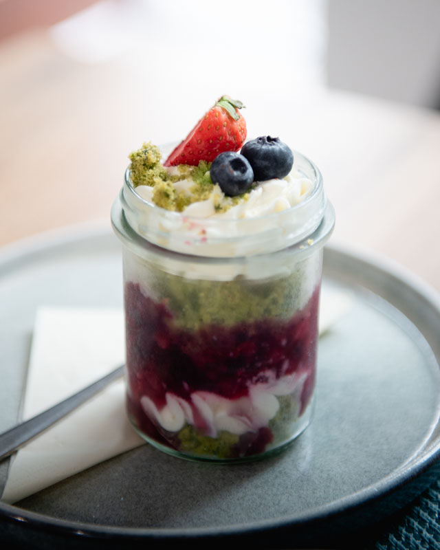 Muž v černém kabátu s rukou ve vlasech, černobílá fotka