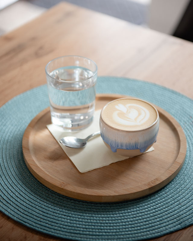 Muž ve vojenské bundě stojí před průmyslovou halou