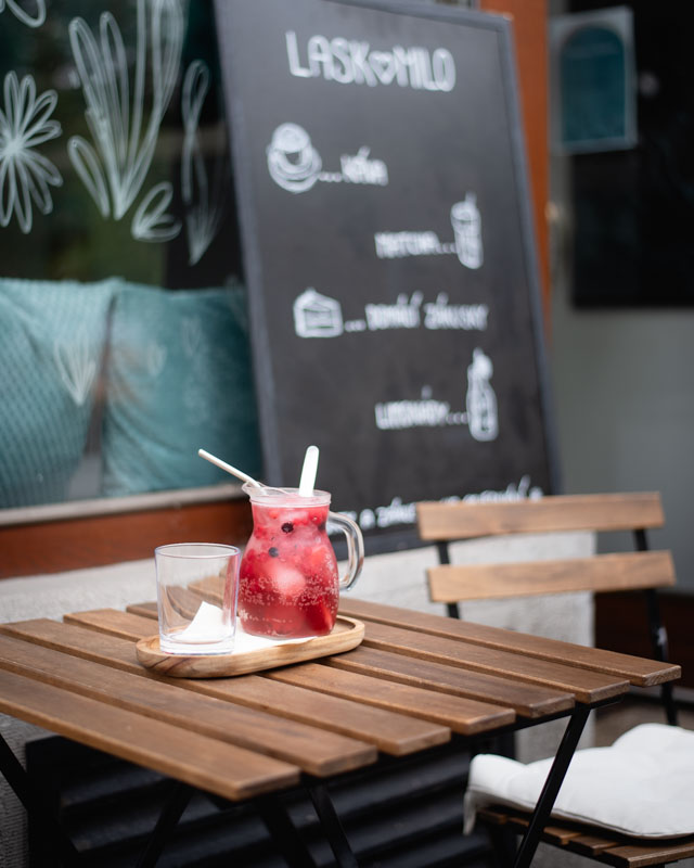 Muž kráčí po dlážděné ulici mezi cihlovými domy