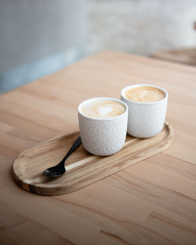 Muž sedí na zídce v parku, černobílá fotka