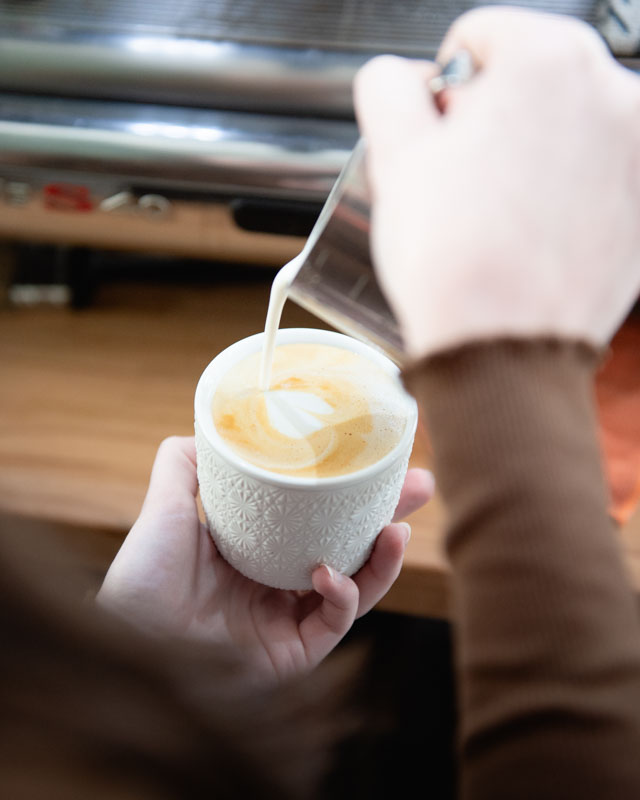 Muž se zkříženýma rukama před industriální budovou